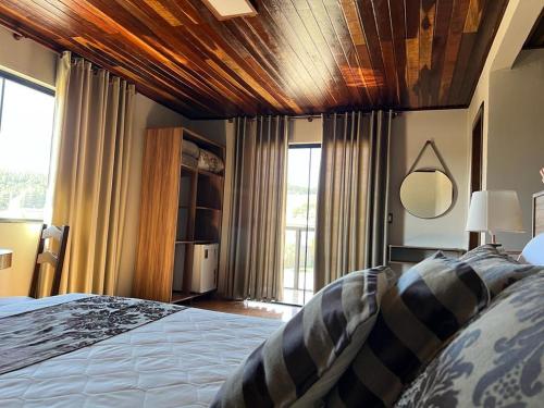 um quarto com uma cama grande e uma janela grande em Pousada Serra Geral em Cambará