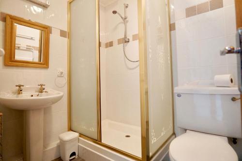 a bathroom with a shower and a toilet and a sink at Special 2 Bedroom Home in White Cross in Saint Columb Major