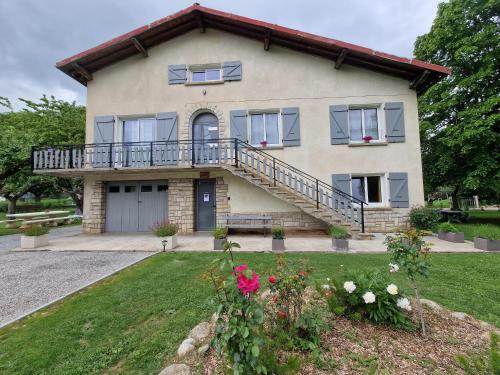 een huis met een veranda en een balkon bij chambre d'hôtes Ô rendez-vous in Roquefeuil