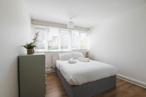 a bedroom with a bed with two towels on it at Stylish & Tranquil Flat with Excellent Connections in London