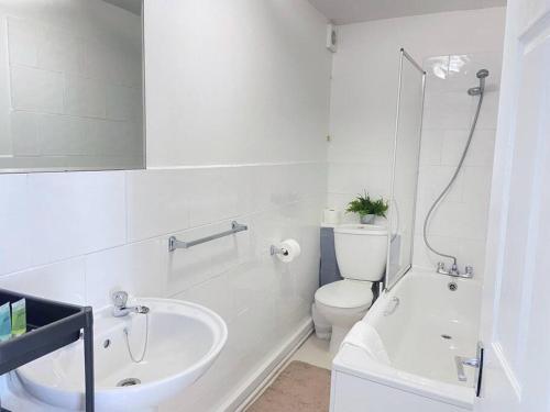 a white bathroom with a toilet and a sink at Stylish & Tranquil Flat with Excellent Connections in London