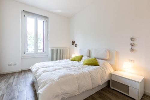a white bedroom with a large bed and a window at Bellarmino 21 in Milan