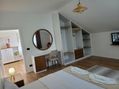 a white room with a bed and a mirror at Bujtina Bezhani Gjinar in Elbasan