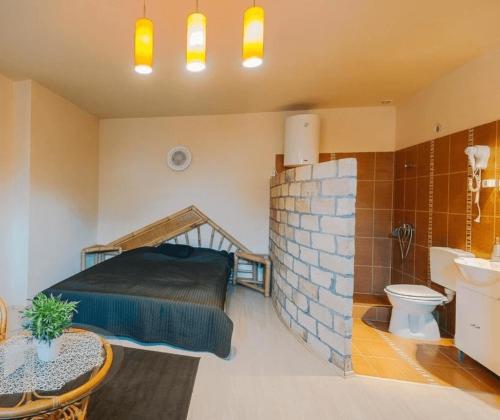 1 dormitorio con 1 cama y baño con lavamanos en Páva Panzió, en Soltvadkert