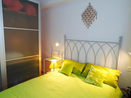 una camera da letto con un letto grande con cuscini gialli di Apartamento Córdoba con encanto LUBI II a Cordoba