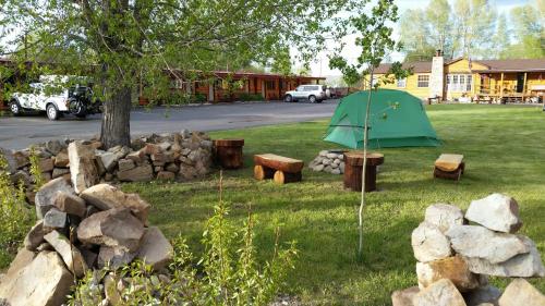 a green tent and some rocks and a tree at Long Holiday Motel in Gunnison