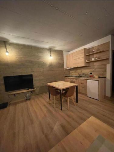 a living room with a table and a kitchen at Mavrovo Apartment in Mavrovo