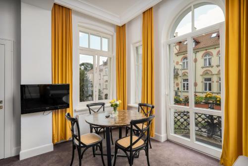 a dining room with a table and chairs and a window at So in Sopot Apartments in Sopot