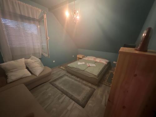 um pequeno quarto com uma cama e um sofá em Gabe's Nest em Üröm