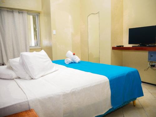 a bedroom with a bed with a teddy bear on it at Marbello Ariau Hotel in Fortaleza