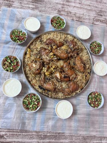 a pan of food on a table with bowls of food at شقة سيلا in Irbid