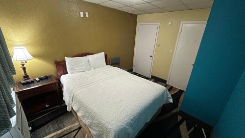a bedroom with a bed and a lamp on a table at Extended Stay Motel - Snyder in Snyder