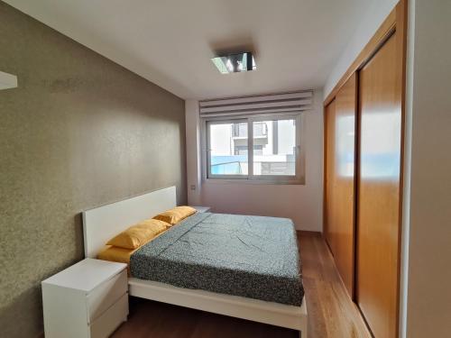 a small bedroom with a bed and a window at Family apartment Forum in Barcelona