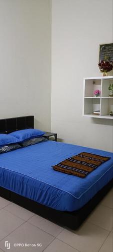 a bedroom with a bed with a blue comforter at RWA Segamat homestay in Segamat