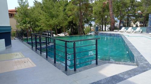 a swimming pool with a glass table and chairs at Han Apart Otel in Didim
