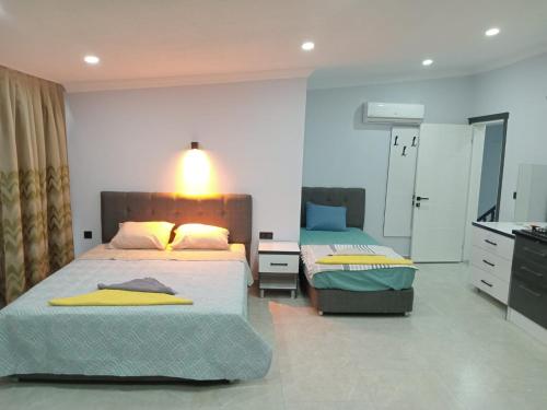 a bedroom with two beds and a dresser in it at Han Apart Otel in Didim