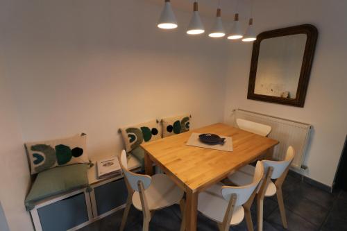 a dining room with a wooden table and chairs at Maison avec terrasses à 300m de la mer Juno Beach in Bernières-sur-Mer