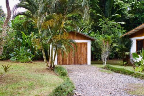 a house with a wooden garage in a garden at Casa Lucas in Cahuita
