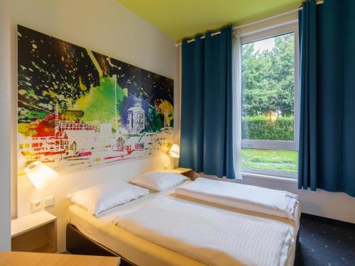 a bedroom with two beds and a window at B&B Hotel Mülheim an der Ruhr in Mülheim an der Ruhr