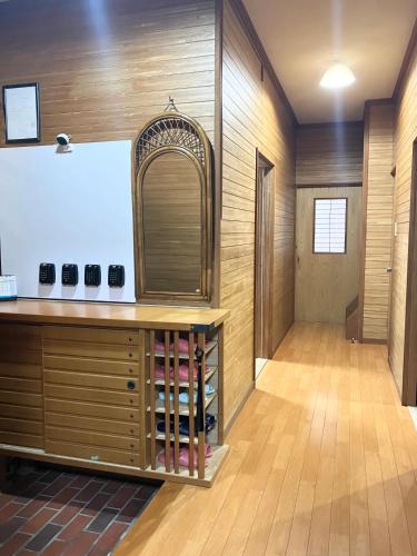 a large room with a wooden wall with a whiteboard at KIX House Waraku III 和楽三号館 in Izumi-Sano
