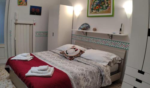 - une chambre avec un lit et des serviettes dans l'établissement La Gorgone, à Casteldaccia