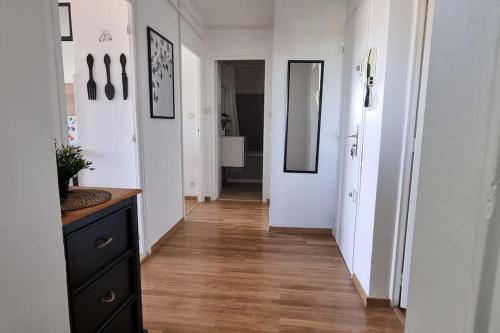 - un couloir avec des murs blancs et du parquet dans l'établissement Super appartement, à proximité de la gare SNCF, à Avignon