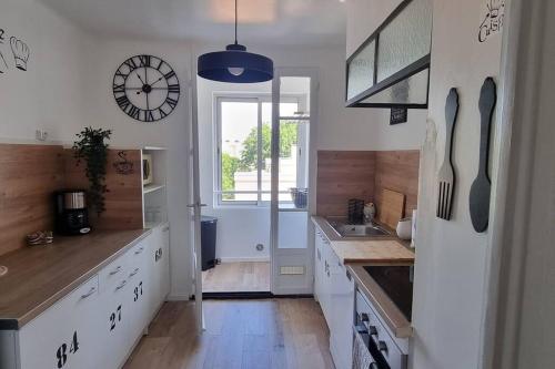 une cuisine avec une horloge murale et un évier dans l'établissement Super appartement, à proximité de la gare SNCF, à Avignon