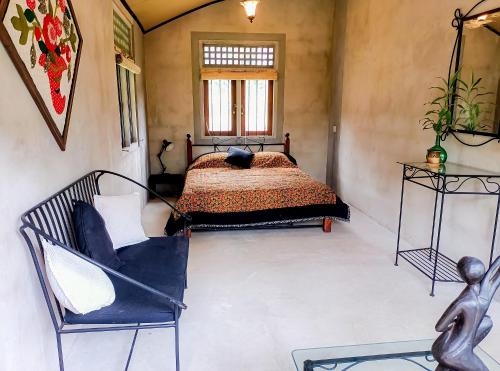 a bedroom with a bed and a chair and a window at Amandawa Eco in Gampaha