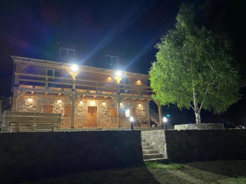 a log cabin at night with lights on it at Montenegro Dream House in Žabljak