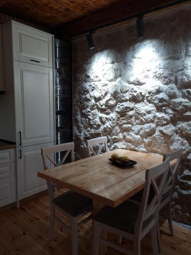 a dining room table with chairs and a stone wall at Montenegro Dream House in Žabljak