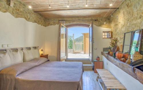 a bedroom with a bed and a large window at Casa Maria - Dimora di Charme in Montalcino