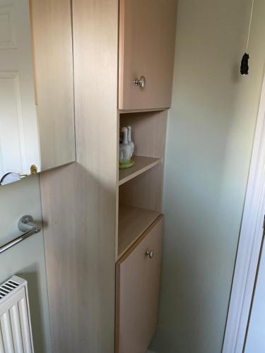 a small kitchen with wooden cabinets and a refrigerator at Cherry Trees 