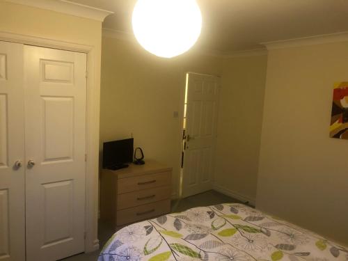 a bedroom with a bed and a light on the ceiling at Cherry Trees in Muxton