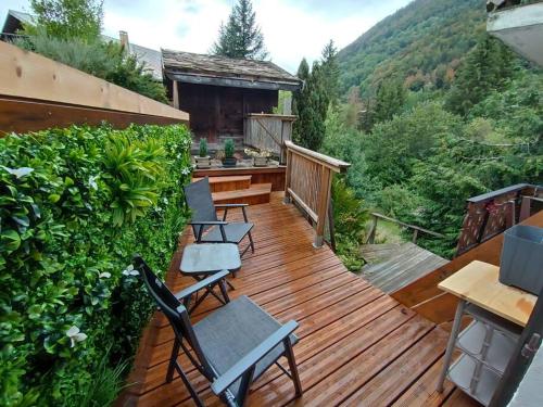 une terrasse en bois avec des chaises et une table dans l'établissement Petite appart charmante!, à Montriond