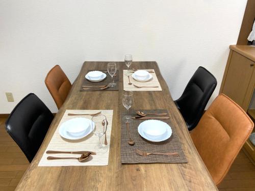 un tavolo di legno con sedie, piatti e bicchieri da vino di 浜町小院别馆 a Takamatsu