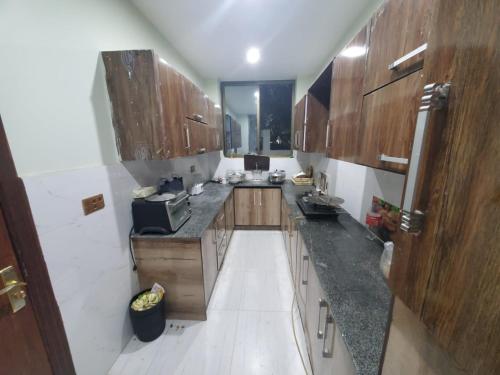 cocina con armarios de madera y encimera en vista guest house en Quetta