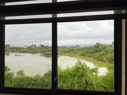 een raam met uitzicht op een rivier bij My House in Puerto Villamil