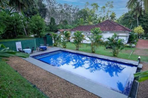 a swimming pool in front of a house at Village Headman's Five Bedrooms Entire Bungalow in Bentota