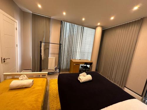 ロンドンにあるThemed Stunning 1-Bed Apartment in Londonの大きな窓付きの客室で、ベッド2台が備わります。