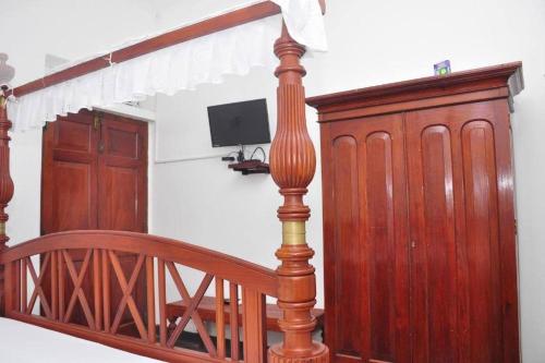 a wooden staircase with a wooden rail and a mirror at Village Headman's Five Bedrooms Entire Bungalow in Bentota