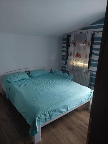 um quarto com uma cama com um edredão azul em Apartman - Jaksa em Bar
