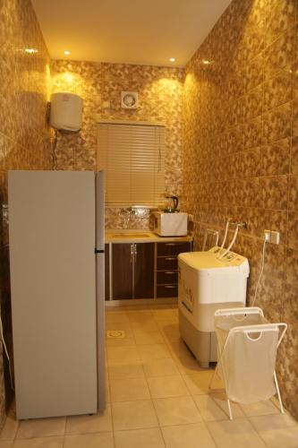 a kitchen with a white refrigerator and a sink at Spacious Apartments at Basla St 3 mins from King Fahd Stadium in Riyadh