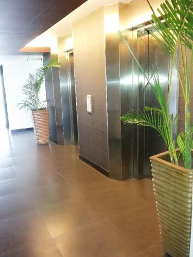 a hallway with two potted plants in a building at GT Hotel Iloilo in Iloilo City