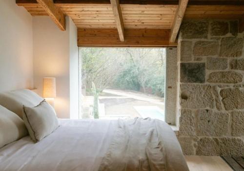 a bedroom with a bed and a large window at Numa Experimental in Pontevedra