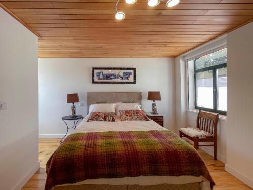 a bedroom with a large bed with a wooden ceiling at Casa Luis Pato in Óis do Bairro