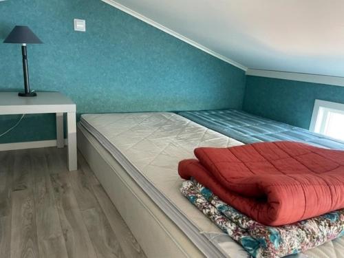 a bedroom with a bed with a red blanket on it at Guest house at Baltic Sea Oskarshamn in Oskarshamn