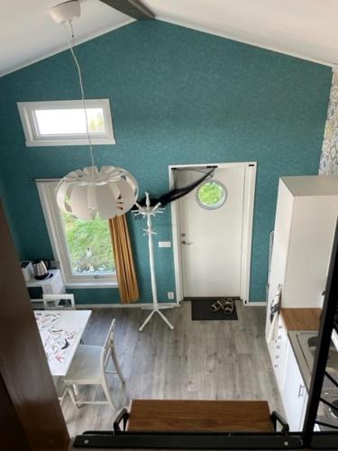 a living room with a green wall and a chandelier at Guest house at Baltic Sea Oskarshamn in Oskarshamn