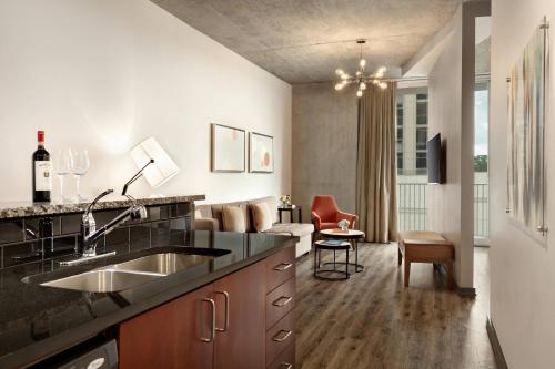 a kitchen with a sink and a living room at Twelve Midtown, Marriott Autograph Collection in Atlanta