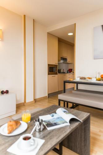 a kitchen with a table with a plate of food on it at Pierre & Vacances Pas de la Casa Princesa in Pas de la Casa