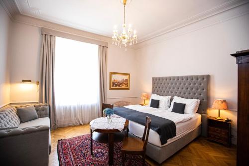 a bedroom with a large bed and a couch at Boutique Hotel Nossek in Vienna